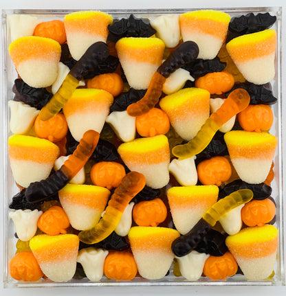 Halloween themed red orange and black gummi Candy Board featuring  gummi bears candy corn bats ghosts and worms that makes a great gift for friends partners and kids and teens