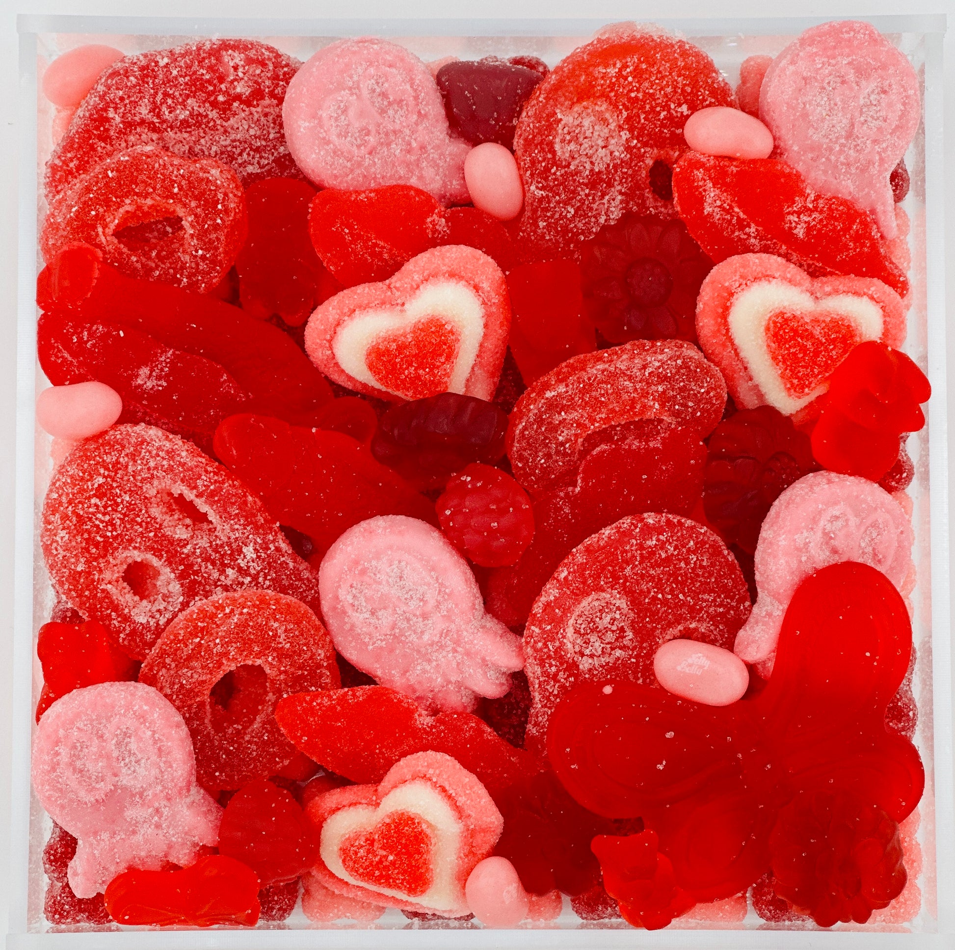 Red pink and white gummi candy board with sweet and sour lips heart skeletons sea creature butterfly berry shaped gummi candy on acrylic tray that makes perfect gift for friend spouse child teen